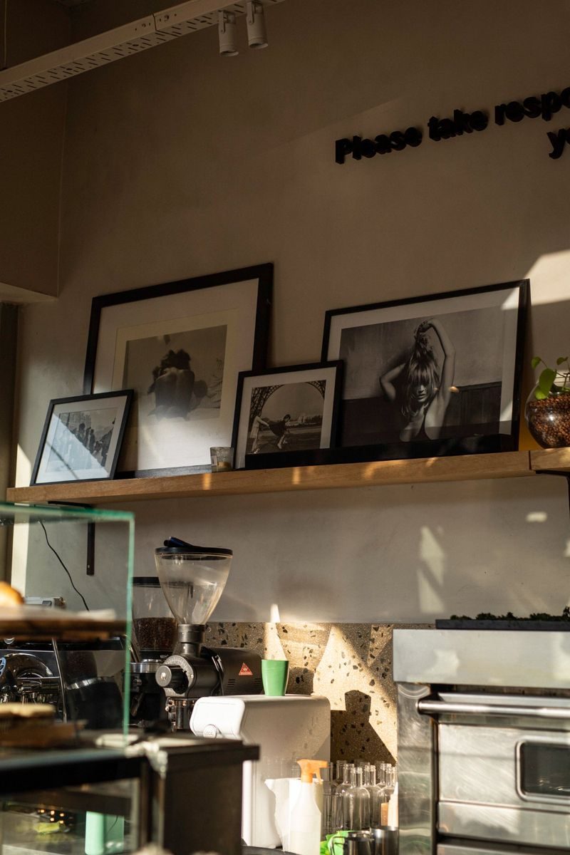 Barra interior SĀNTAL Buenos Aires — cuadros en blanco y negro, barista y equipo espresso con luz cálida